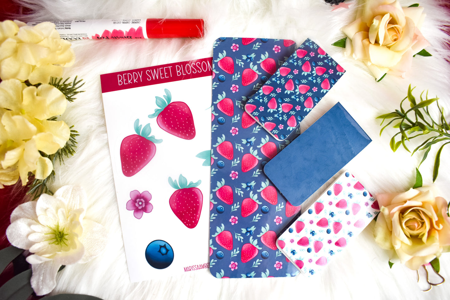 Sticker sheet, traditional bookmark and 3 magnetic bookmarks with strawberry designs on a white background