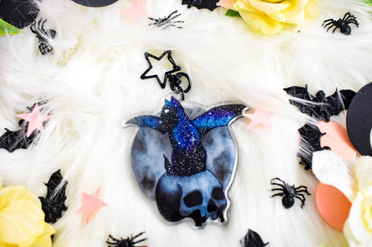 Decorative skull with a cat with bats wings with a starry design on a white background with spider decorations