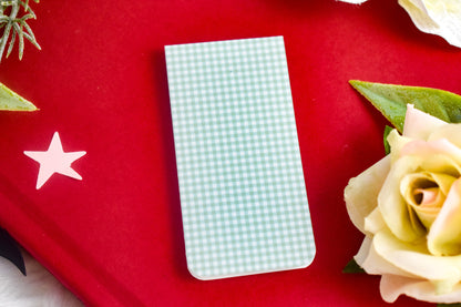 Open book with a green gingham bookmark surrounded by yellow flowers