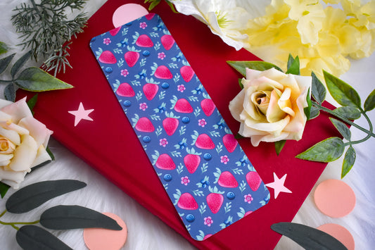 Blue bookmark with strawberry pattern on a red surface with flowers