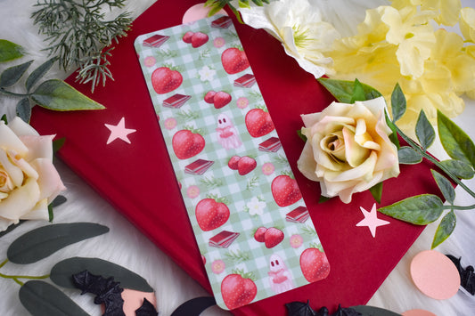 Bookmark with strawberry design on a red book with flowers and leaves.