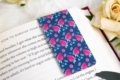 Open book with a blue strawberry patterned bookmark surrounded by yellow flowers