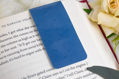 Blue bookmark on a book with a rose in the background