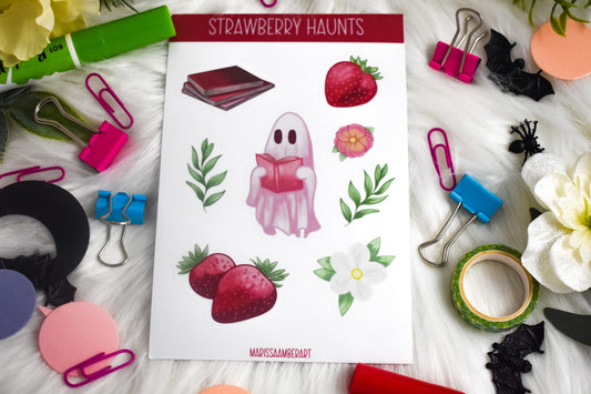 Sheet of 'Strawberry Haunts' stickers with a ghost character, surrounded by stationery items on a white surface.