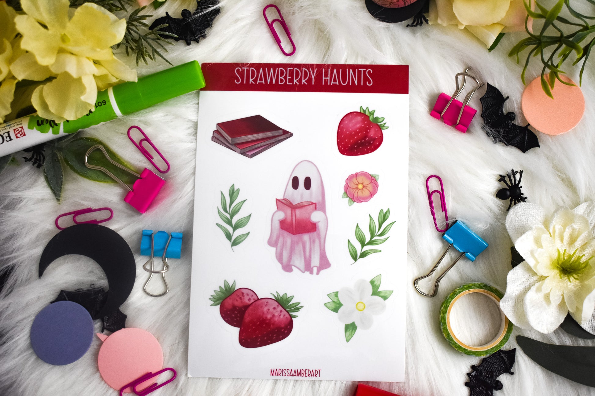 Sheet of 'Strawberry Haunts' stickers with a ghost character, surrounded by stationery items on a white surface.