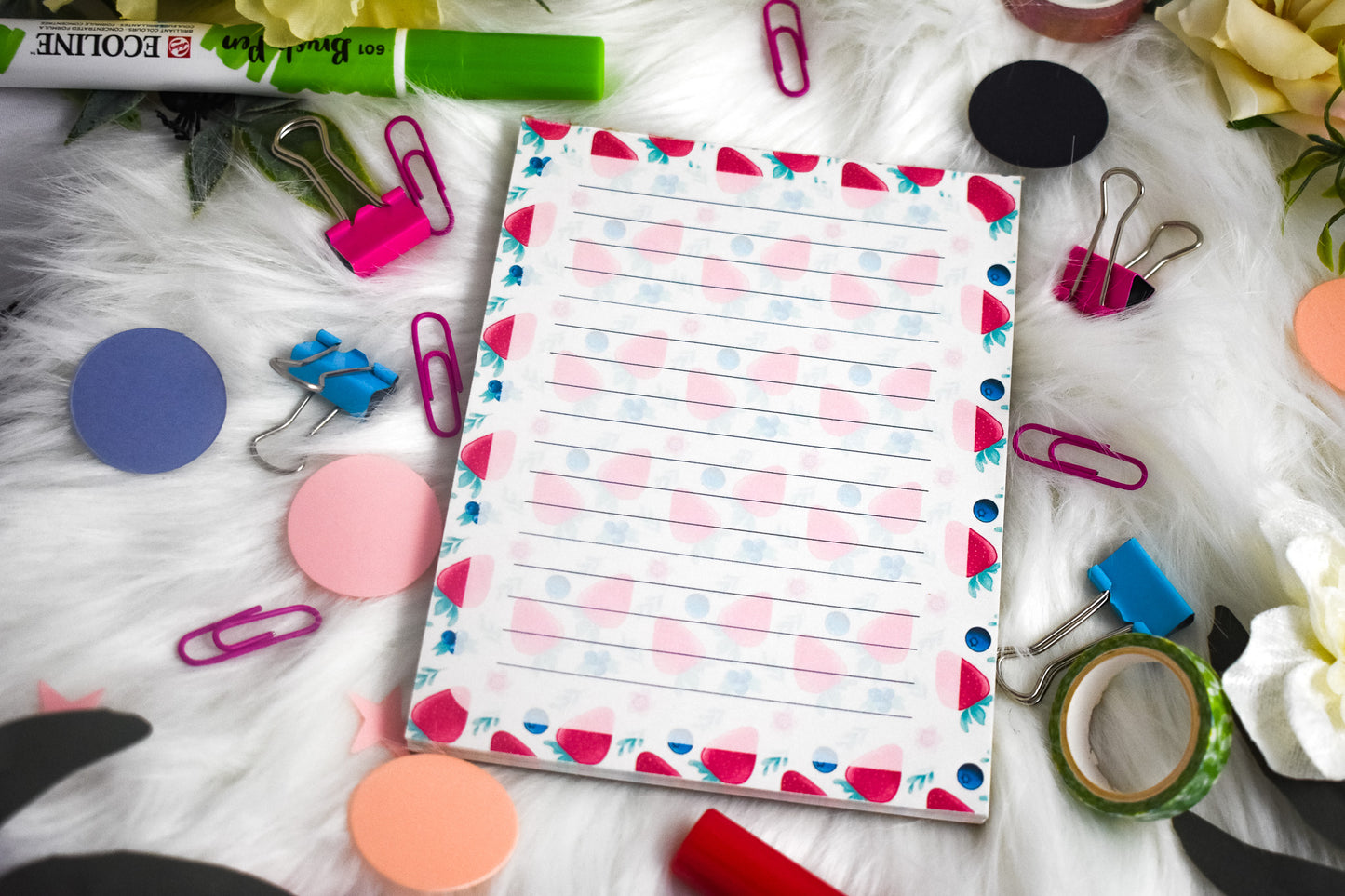 Colorful notepad with stationery items on a textured surface