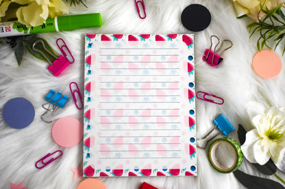 Colorful notepad with stationery items on a white surface