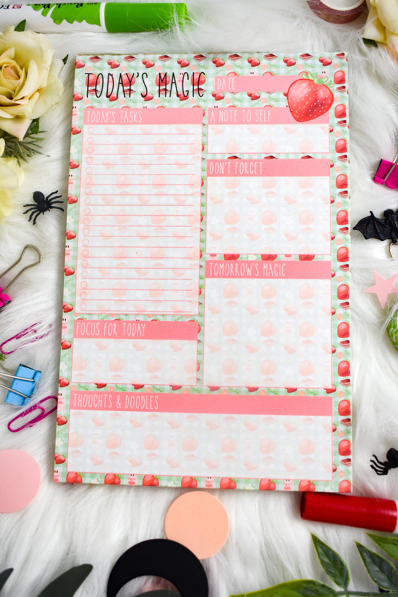 Daily Planner with Halloween-themed design on a decorative surface with flowers and stationery items.