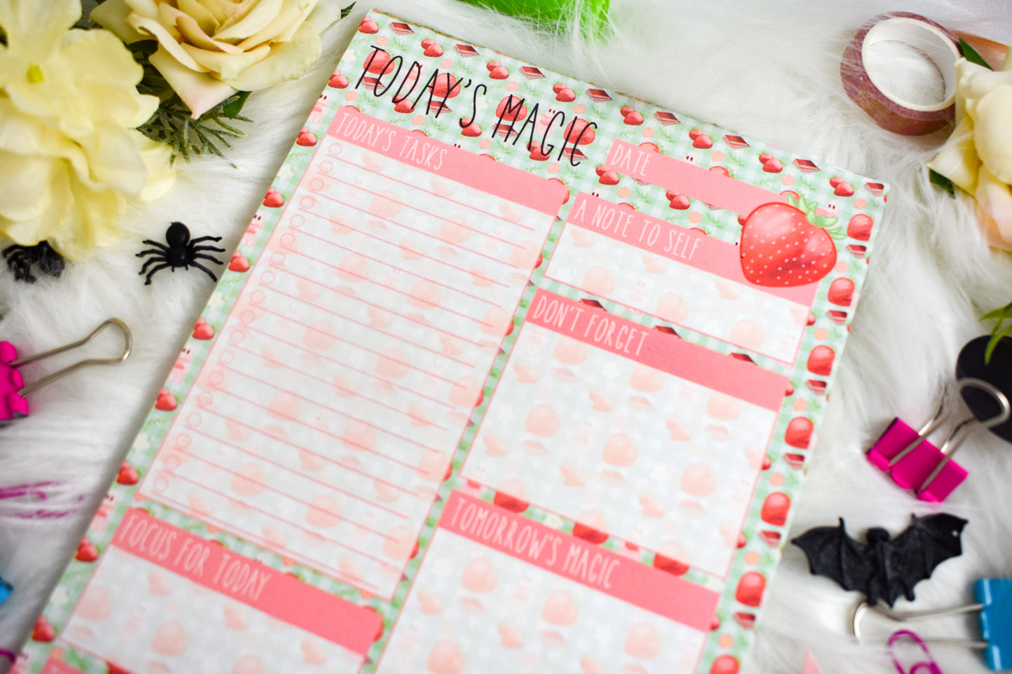 Daily Planner with Halloween-themed design on a decorative surface with flowers and stationery items.