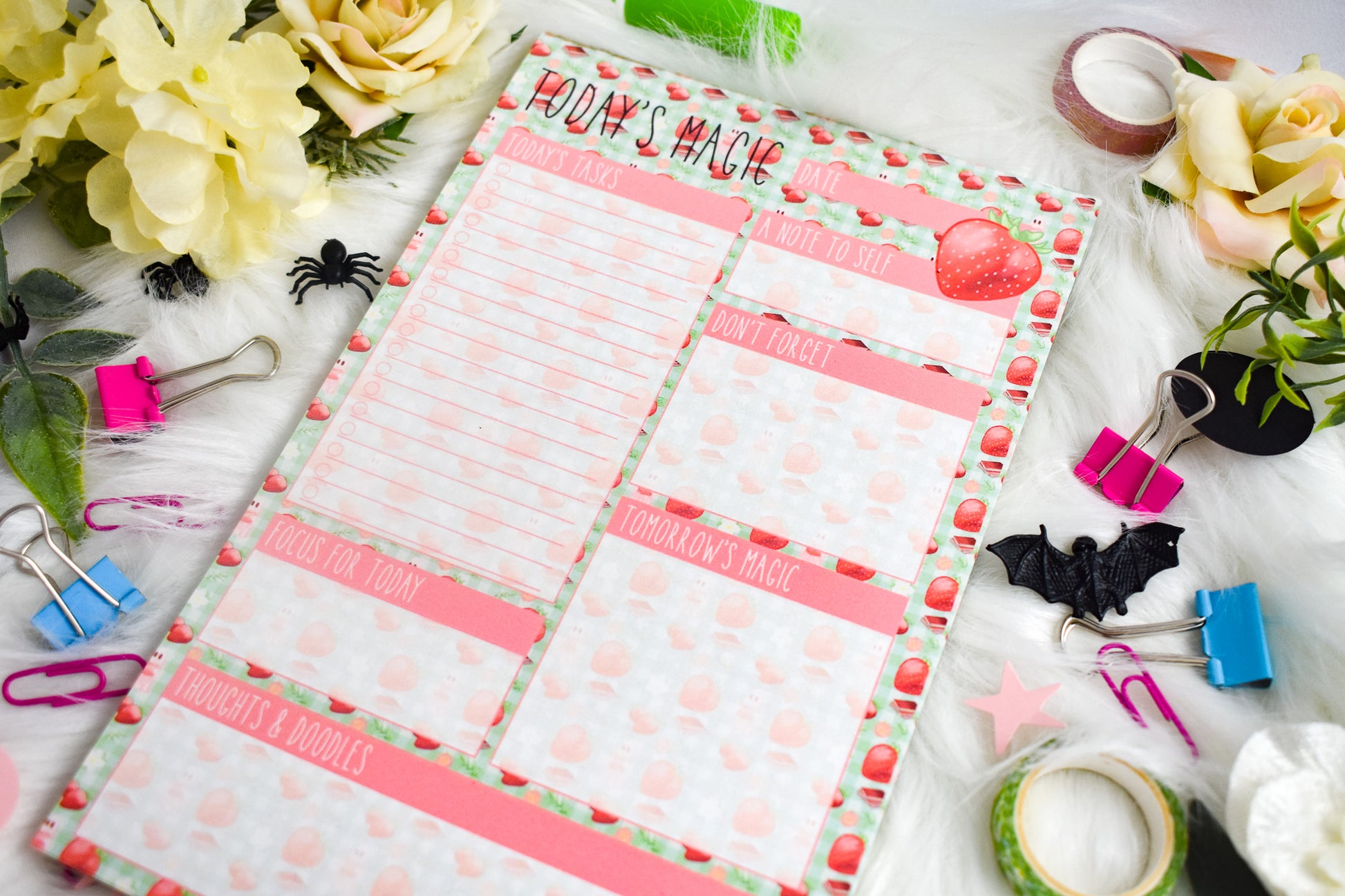 Daily Planner with Halloween-themed design on a decorative surface with flowers and stationery items.