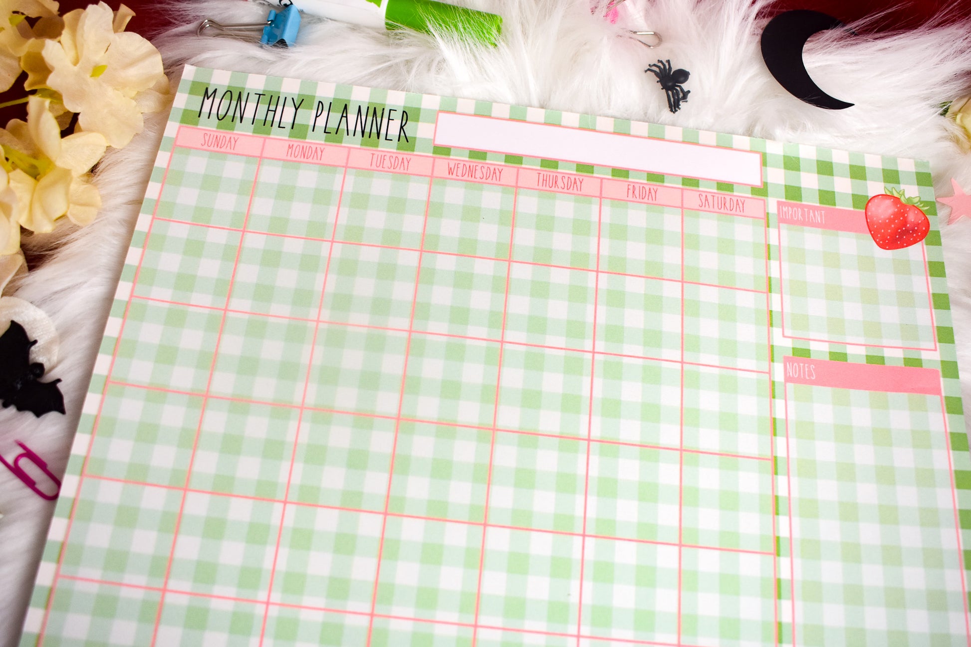Monthly planner with a green and white checkered design on a decorative background.