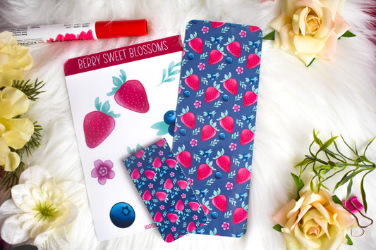 Sticker sheet, magnetic bookmark and traditional bookmark with strawberry design, surrounded by flowers on a white background.